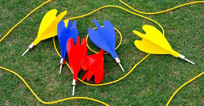 Red, blue and yellow darts in yellow circles on grass