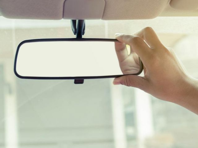 Hand adjusting car rearview mirror