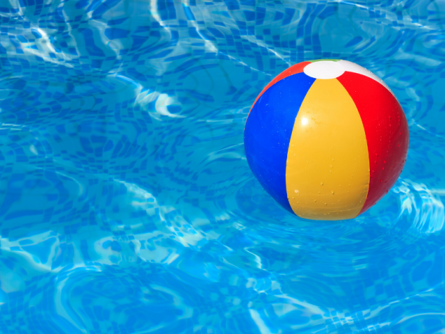 Blue, yellow and red beach ball floating in a pool