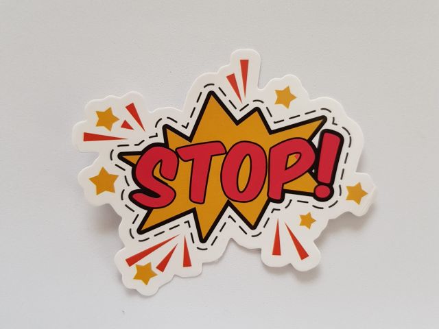 Yellow and red sticker that says "Stop!"