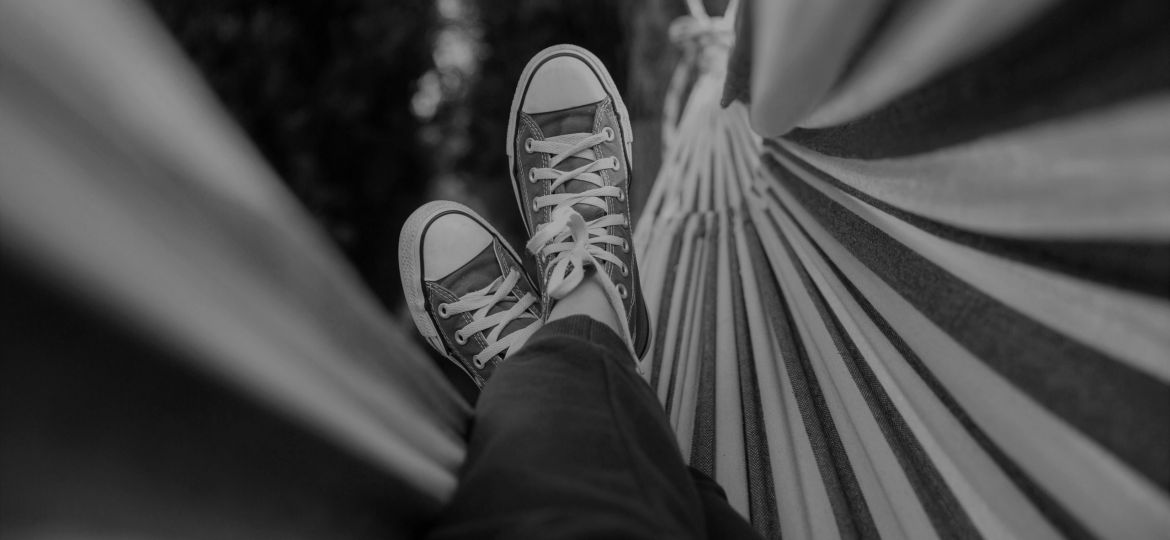 Black and white photo of person's feet in a hammock
